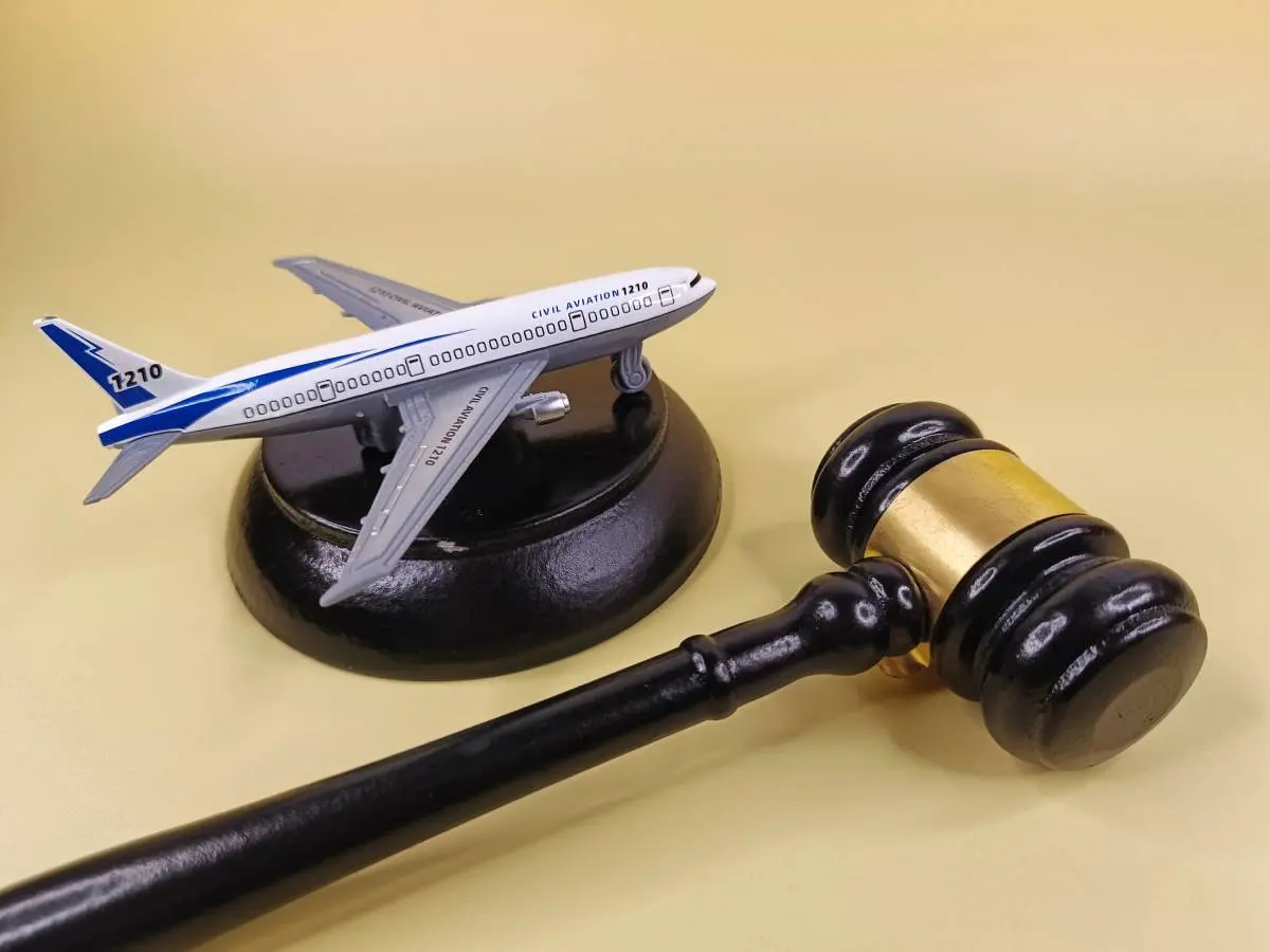 a miniature airplane on a judge's gavel against a beige background 