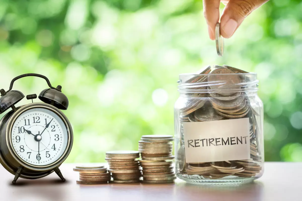 Retirement jar full of coins next to clock