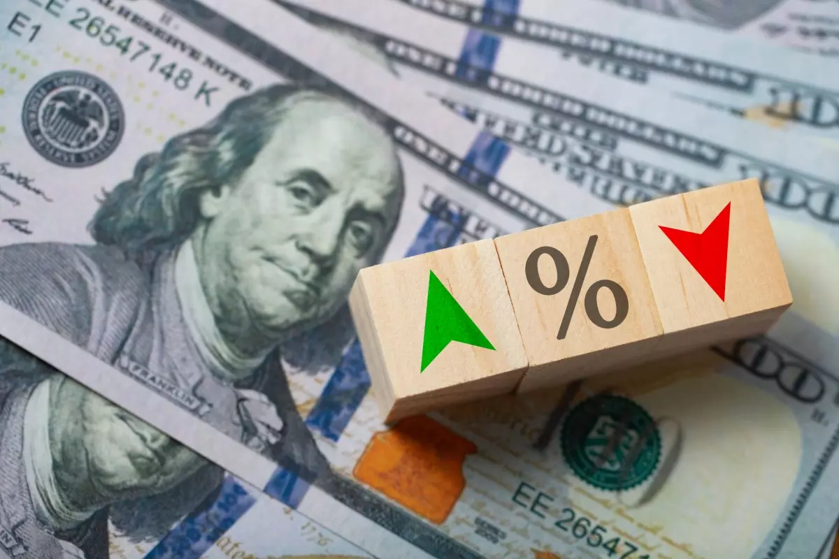 $100 bills with wooden arrow blocks in red and green on top